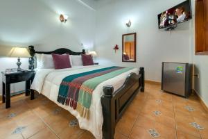 a bedroom with a bed and a television at Casa Del Curato in Cartagena de Indias