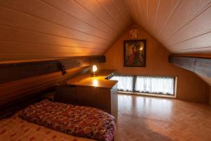 a attic room with a bed and a desk in it at Vineyard cottage Hočevar in Novo Mesto