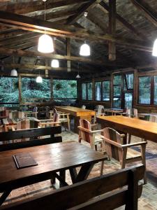 a restaurant with wooden tables and chairs and lights at Cabana Zimbru Transfagarasan in Arefu