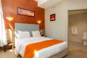 una camera da letto con un letto grande e un bagno di Kyriad Avignon - Palais des Papes ad Avignone