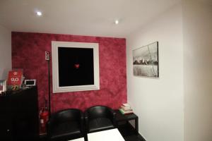 una camera con una parete rossa, tavolo e sedie di Star of Rome a Roma