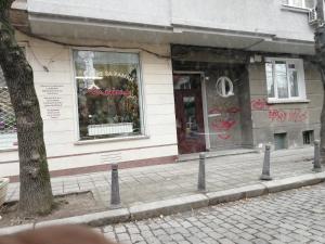 a store on the side of a street with graffiti at Cozy apartment in the heart of Sofia in Sofia