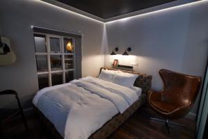 a bedroom with a bed and a chair and a window at Hotel Akureyri Dynheimar in Akureyri