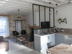 una cucina e un soggiorno con tavolo e sedie di GITE IZALIN AVEC SPA A 20 min du Puy du Fou a Mauléon