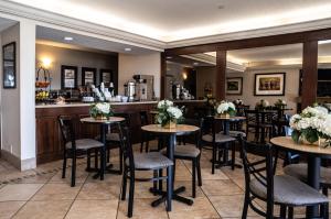 um restaurante com mesas e cadeiras e um bar em Hatfield Inn em Leitchfield