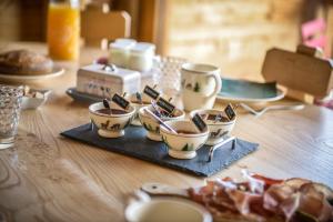 una mesa de madera con tazas de café en un plato en La grange d'Aldaré Chambres d'hôtes, en Combloux