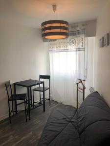 a dining room with a table and chairs and aendant light at Résidence Le Club in Saint-Jean-de-Monts +19 photos