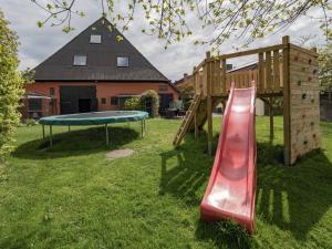 a playground with a slide and a trampoline at Ferienwohnung-Rosenrot-auf-dem-Ferien-Bauernhof-Nilson-in-Inselmitte in Bisdorf