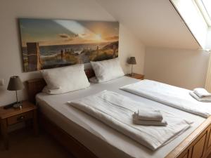 a bedroom with two beds and a painting on the wall at Gästehaus am Wasserpark in Rust