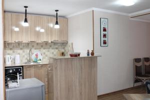 a kitchen with wooden cabinets and a counter top at Guest House ELENA in Kutaisi
