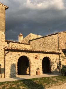 un bâtiment en pierre avec une tour en haut dans l'établissement Agriturismo Materno, à Radicondoli