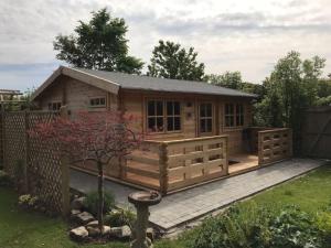 Cabaña de madera con terraza y valla en The Cabin en Chester