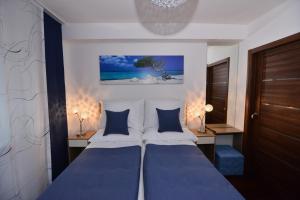 um quarto com 2 camas e almofadas azuis em Apartmani FAMILY em Sveti Filip i Jakov