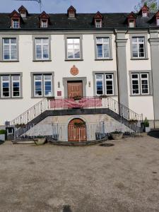 a large white house with a staircase in front of it at Gästehaus der Abtei Sayn in Bendorf