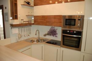 a kitchen with a sink and a microwave at Apartmani FAMILY in Sveti Filip i Jakov