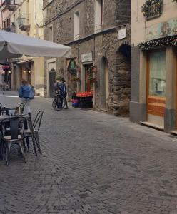 eine leere Straße mit Tischen und Stühlen auf einer Kopfsteinpflasterstraße in der Unterkunft Casa vacanza croce di città CIR 0071 in Aosta