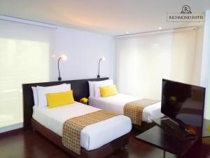 2 camas en una habitación de hotel con TV en Richmond Suites Hotel, en Bogotá