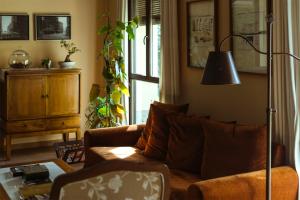 ein Wohnzimmer mit einem Sofa und einer Lampe in der Unterkunft El Tiempo Recobrado - Hotel de silencio y relax in Villamartín de la Abadía