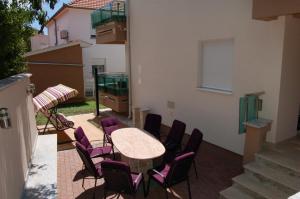 a patio with a table and chairs on a balcony at Apartmani FAMILY in Sveti Filip i Jakov