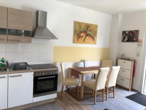 una cucina con tavolo, sedie e piano cottura di Ferienwohnung A.Engelhardt a Nordhausen