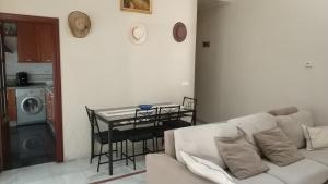 a living room with a white couch and a table at Pension Perez Montilla in Seville