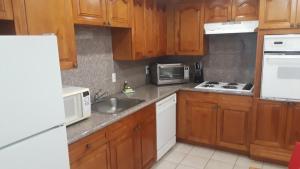 a kitchen with wooden cabinets and a sink and a microwave at Tides Apt on Hollywood Beach in Hollywood