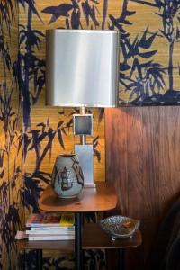 a lamp on top of a table with a book at CHAMBRE AVEC VUE in Domessin