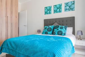 a bedroom with a blue bed with blue pillows at Alimama Spaces: Vik Whisken in Midrand +20 photos
