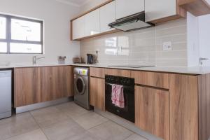 a kitchen with wooden cabinets and a dishwasher at Alimama Spaces: Vik Whisken in Midrand