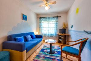 a living room with a blue couch and a table at Apartments Helena, Mali Lošinj in Mali Lošinj