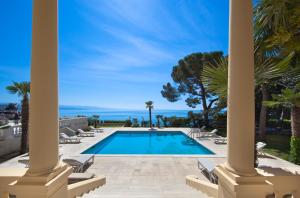 a pool with chairs and the ocean in the background at Villa Amalia - Liburnia in Opatija