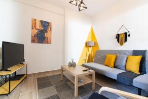 un salon avec un canapé bleu et une télévision dans l'établissement F & B Collection - Apartment for 6, à Thessalonique