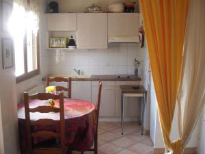 a small kitchen with a table and a table and chairs at LE ROSSIGNOL in Cranves-Sales