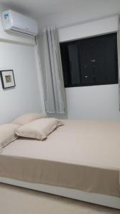 a bed in a room with a window at Apartamento de luxo no coração da ponta verde in Maceió