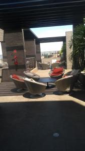 un patio con sillas, mesa, mesas y sillas en Apartamento de luxo no coração da ponta verde, en Maceió