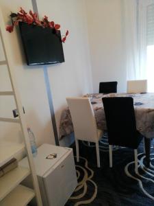 クアルトゥ・サンテーレナにあるI Fioriのテーブル、椅子、壁掛けテレビが備わる客室です。