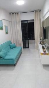 a living room with a blue couch and a television at Apartamento de luxo no coração da ponta verde in Maceió