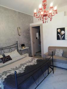クアルトゥ・サンテーレナにあるI Fioriのベッドルーム1室(ベッド1台、シャンデリア、ソファ付)