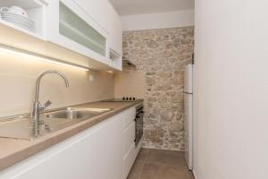 Kuchyňa alebo kuchynka v ubytovaní Apartmani Mustaća dvori + 33 fotografií