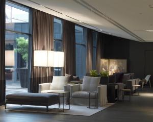 a lobby with couches and chairs and windows at The Met Hotel Thessaloniki, a Member of Design Hotels in Thessaloniki