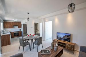 uma sala de estar com uma mesa de jantar e uma televisão em Rio Luxury Apartment em Agia Napa