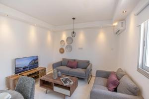uma sala de estar com dois sofás e uma televisão em Rio Luxury Apartment em Agia Napa