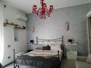a bedroom with a bed and a red chandelier at I Fiori in Quartu SantʼElena