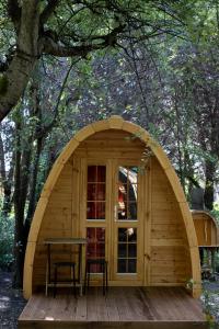 un pequeño cobertizo de madera con una mesa y un banco en Camping Dolce Sole, en Marina di Massa
