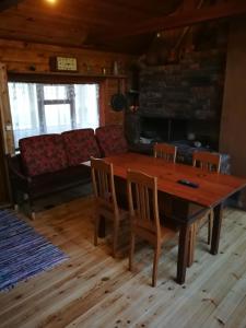 a dining room with a table and chairs and a couch at Sodyba Vieversyne in Duokiškis