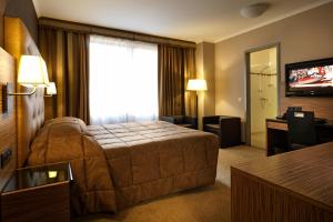 um quarto de hotel com uma cama e uma televisão em Hyllit Hotel em Antuérpia