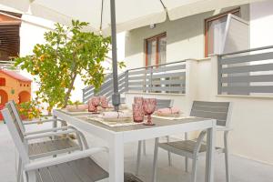 a white table and chairs on a patio at Meltemi luxury apartments in Nea Roda