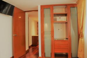 Habitación con armario de madera y cocina. en Condesa Suites en Ciudad de México