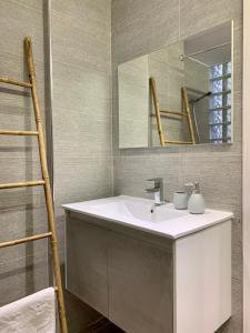 a bathroom with a sink and a mirror at Xsoma Flats "Twins" in Thessaloniki