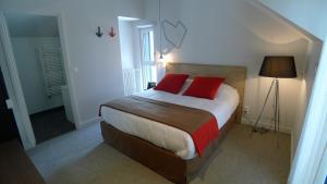 a bedroom with a bed with two red pillows at Hôtel Ar Iniz in Saint Malo